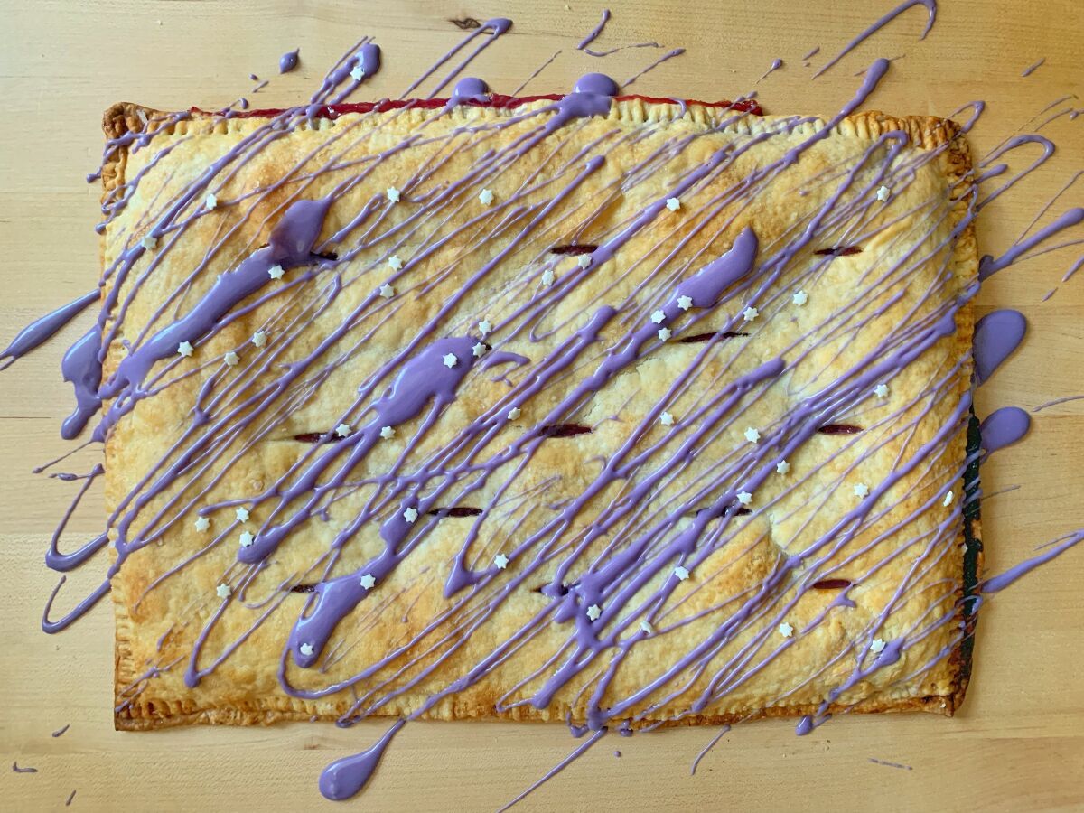 A rectangular pastry with drizzles of lavender icing.