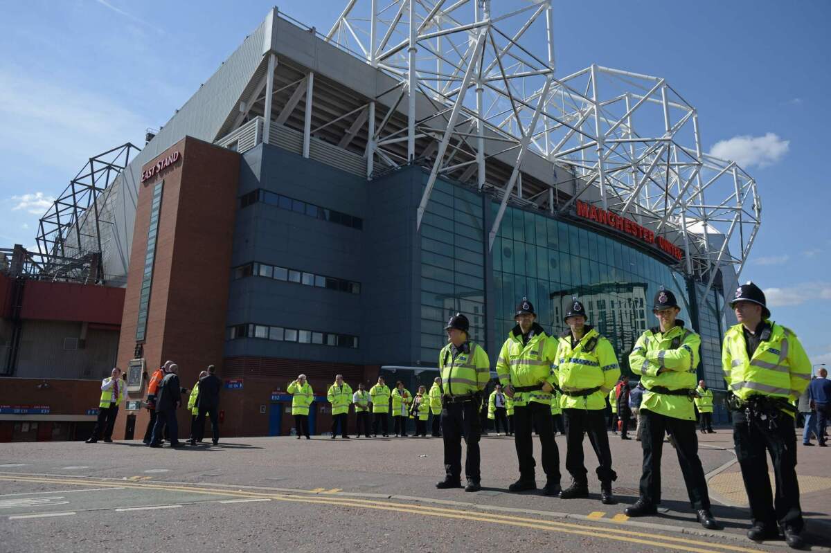 Police officers stand outside Old Trafford stadium in Manchester after the English Premier League soccer match between Manchester United and Bournemouth was called off.