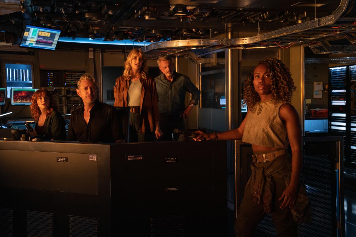 Five people in a control room look serious
