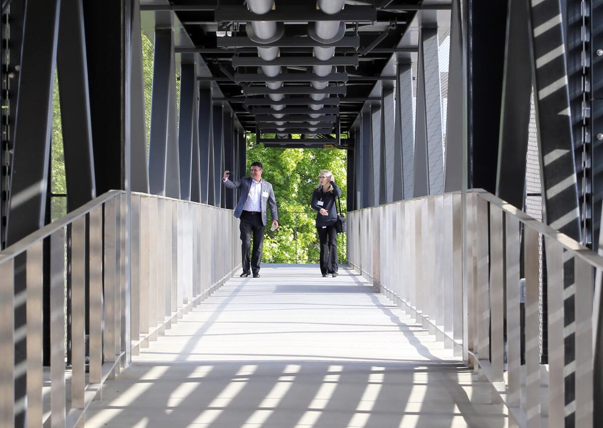 Guests walk through the pedestrian skybridge, a 220-foot, open-air covered bridge at the O.C. Sanitation District.