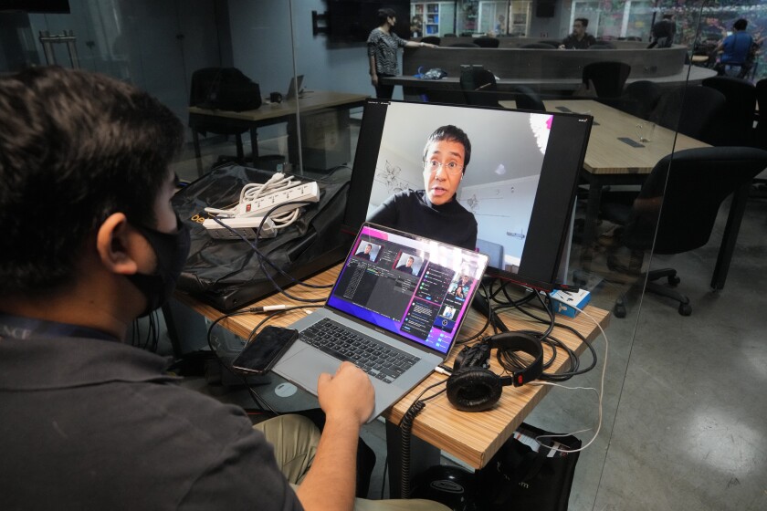 A staff of Rappler monitors as Filipino journalist and Nobel Peace Prize winner Maria Ressa talks during a zoom meeting that is seen inside their office in Pasig city, Philippines on Wednesday, June 29, 2022. Ressa said her Rappler news website was operating “business as usual” Wednesday and would let Philippine courts decide on a government order to close the outlet critical of the outgoing Duterte administration and its deadly drug crackdown. (AP Photo/Aaron Favila)