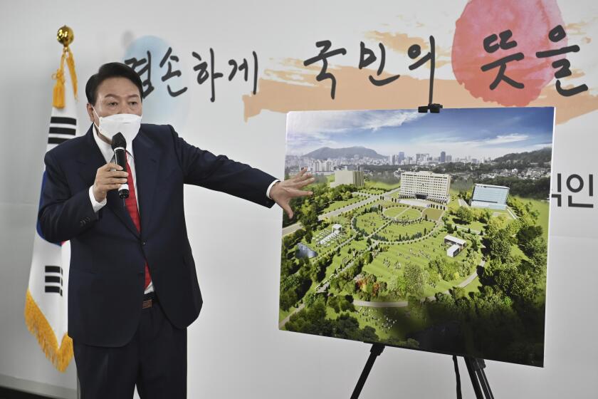 FILE - South Korea's President-elect Yoon Suk Yeol shows a bird's eye view of his planned relocation of the presidential office during a news conference in Seoul, South Korea, Sunday, March 20, 2022. South Korea’s outgoing liberal government expressed its opposition to a plan by President-elect Yoon to relocate the presidential office by his inauguration in May, a development that could put Yoon’s ambitious project in doubt and trigger a domestic political firestorm. (Jung Yeon-je/Pool Photo via AP, File)