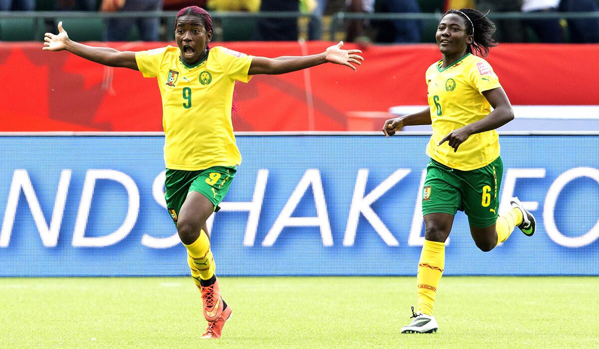 Cameroon's Madeleine Ngono, left, and Francine Zouga celebrate a goal against Switzerland during the second half of a FIFA Women's World Cup match on Tuesday. Cameroon is just the second African country team to ever advance to the round of 16.