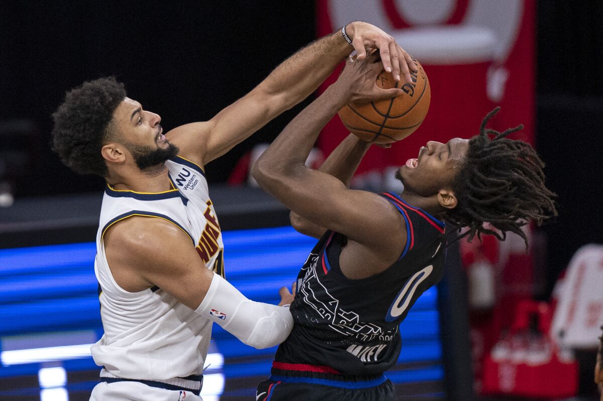Denver Nuggets' Jamal Murray, left, blocks the shot attempt by Philadelphia 76ers' Tyrese Maxey, right, during the first half of an NBA basketball game, Saturday, Jan. 9, 2021, in Philadelphia. (AP Photo/Chris Szagola)