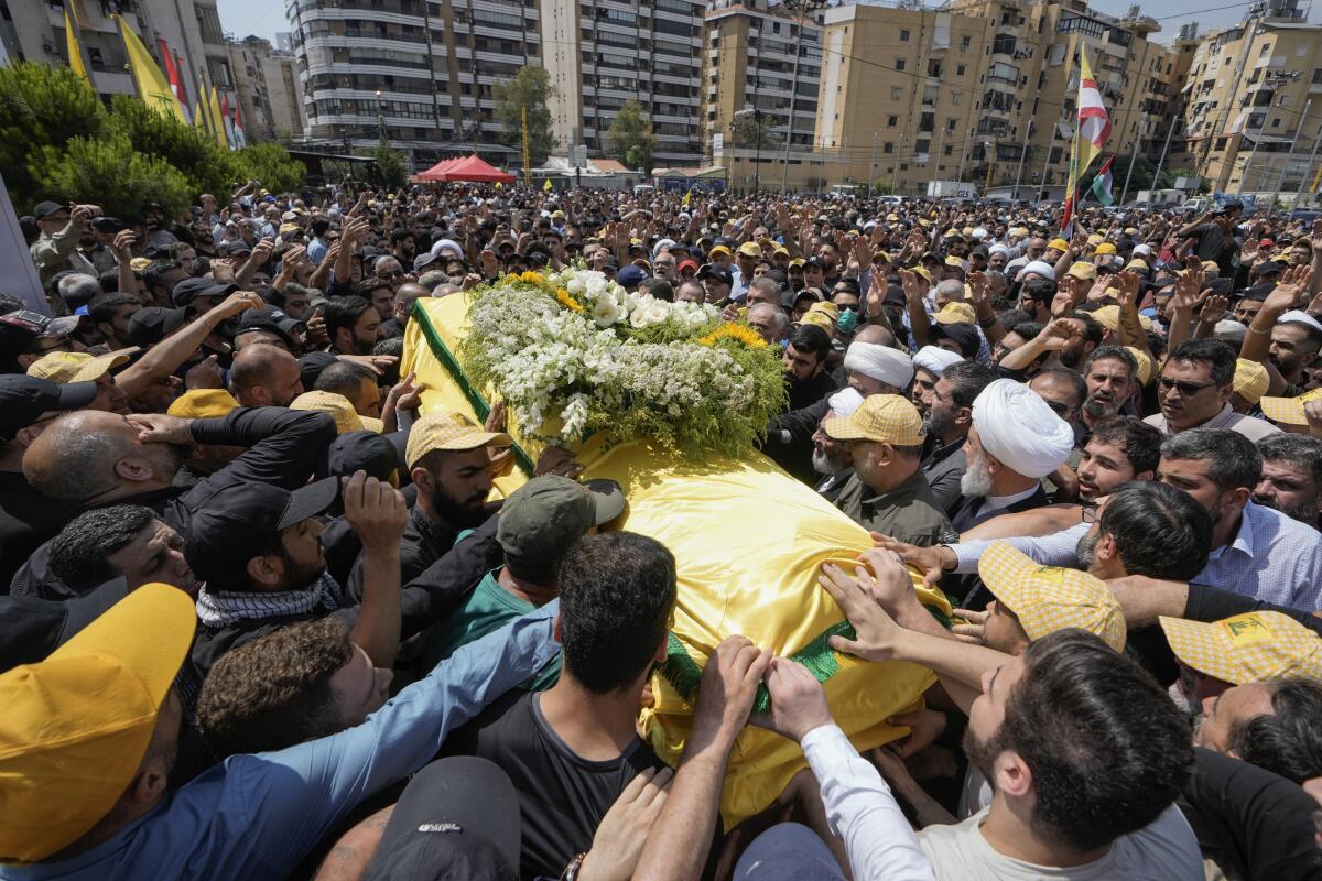 People carry the coffin of Hezbollah senior commander killed late Tuesday 