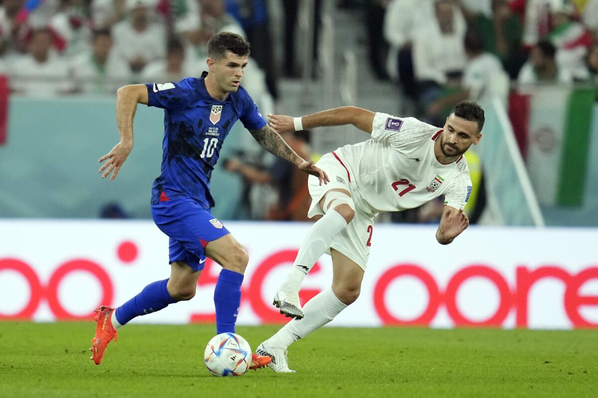 U.S. forward Christian Pulisic, left, controls the ball ahead of Iran's Ahmad Noorollahi during Tuesday's match.