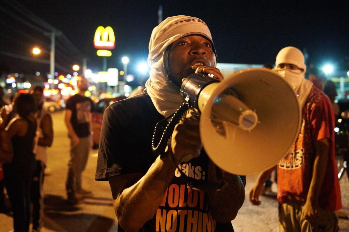 A man encourages demonstrators during an August protest in Ferguson, Mo.