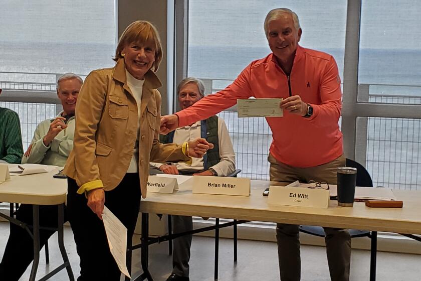 La Jolla Garden Club co-president Pam Filley presents a $1,000 check to Enhance La Jolla president Ed Witt