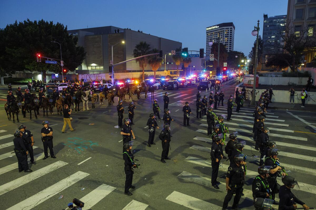 Lines of police officers fill a street at night.