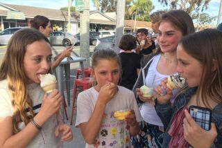 A group of girls sample different flavors at the soft opening of Handel's Homemade Ice Cream in Carlsbad on Monday.