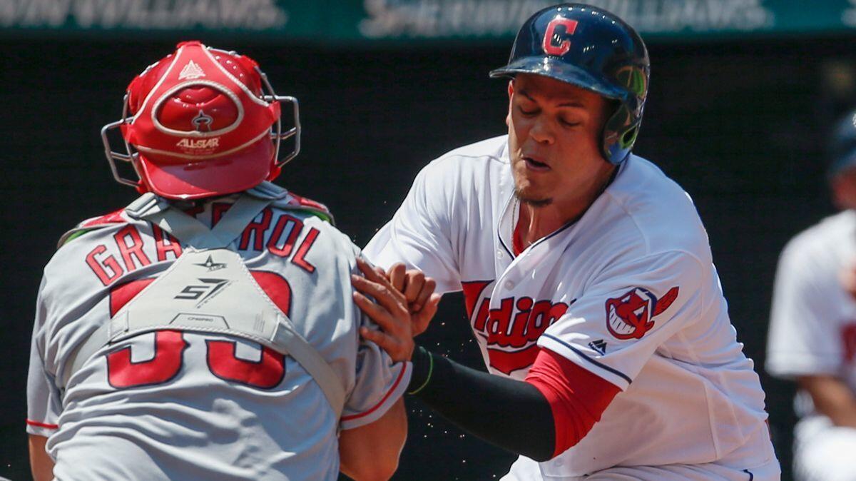 Cleveland Indians' Giovanny Urshela, right, is tagged out by Angels' Juan Graterol while attempting to score in the fifth inning on Thursday.