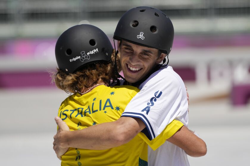 Keegan Palmer of Australia embraces Cory Juneau of the United States, right, during the men's park skateboarding finals at the 2020 Summer Olympics, Thursday, Aug. 5, 2021, in Tokyo, Japan. (AP Photo/Ben Curtis)