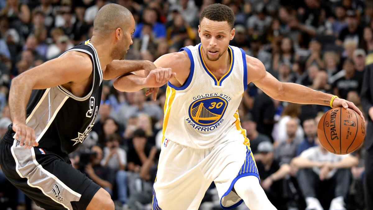 Warriors guard Stephen Curry (30) drives against Spurs guard Tony Parker during the first half Sunday.