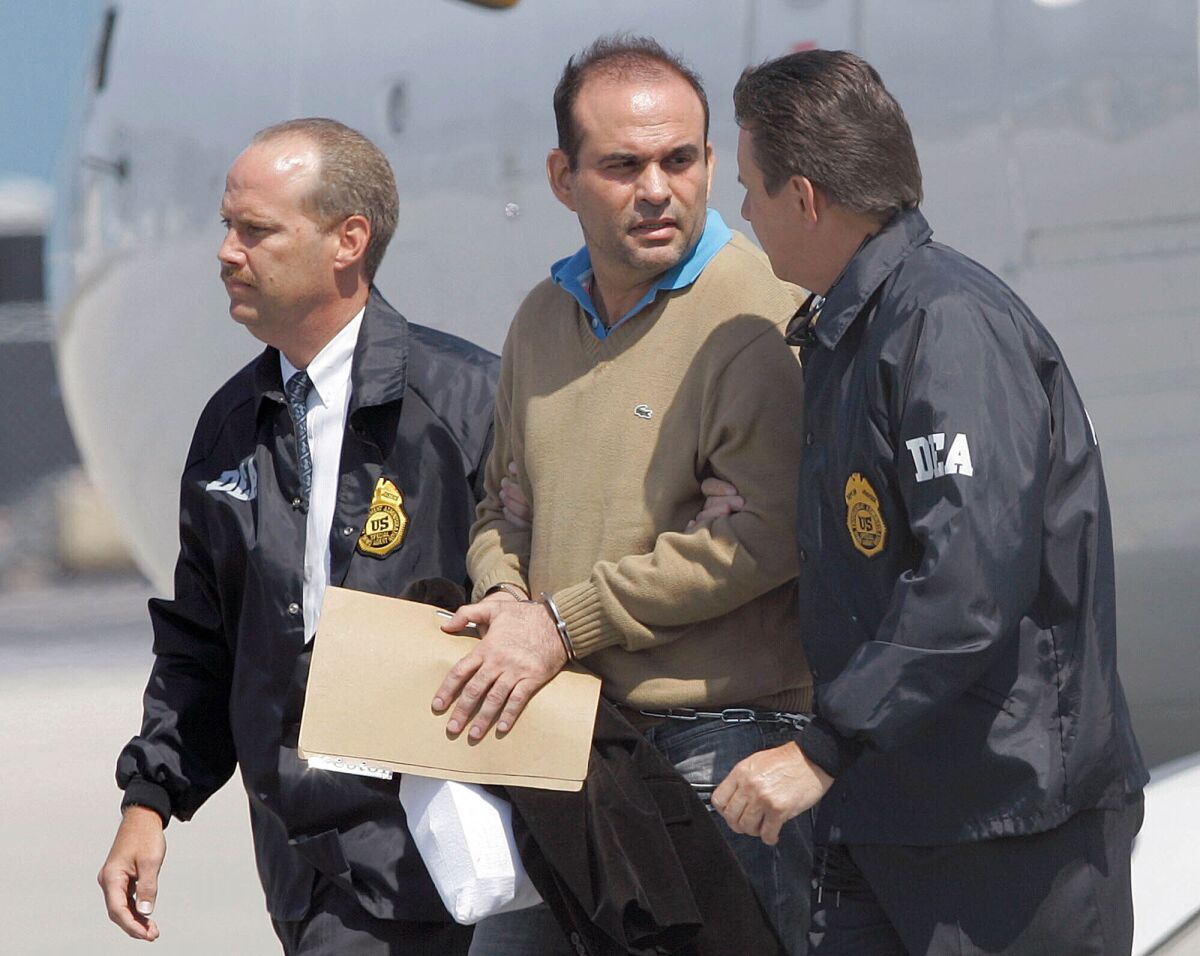 FILE - In this May 13, 2008 file photo, Colombian paramilitary warlord Salvatore Mancuso is escorted by U.S. DEA agents upon his arrival to Opa-locka, Florida. A legal battle is quietly brewing in the U.S. in 2020 over Colombia’s request that this former paramilitary warlord be sent home after completing his drug sentence in the U.S. (AP Photo/Alan Diaz, File)