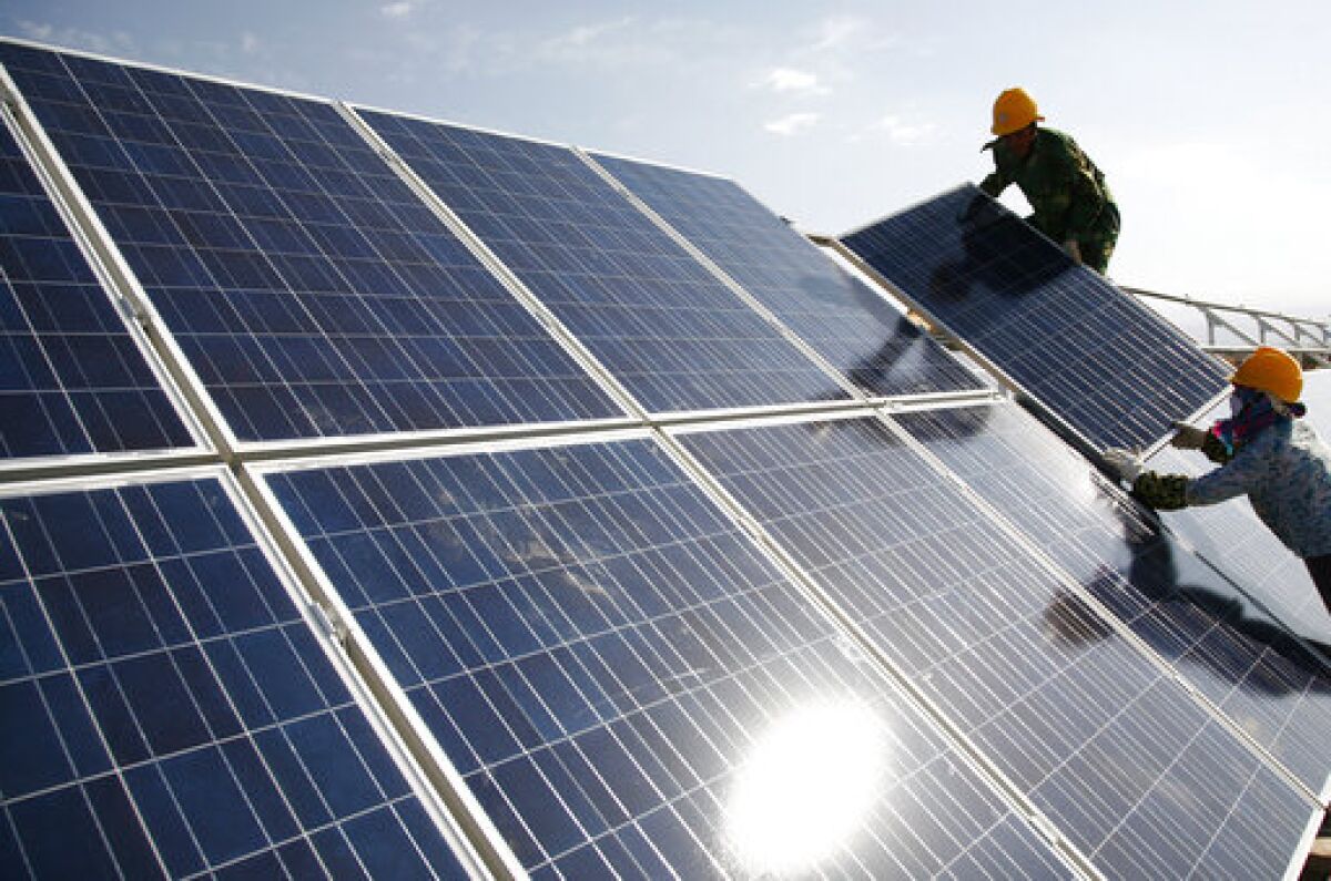 Workers install solar panels.