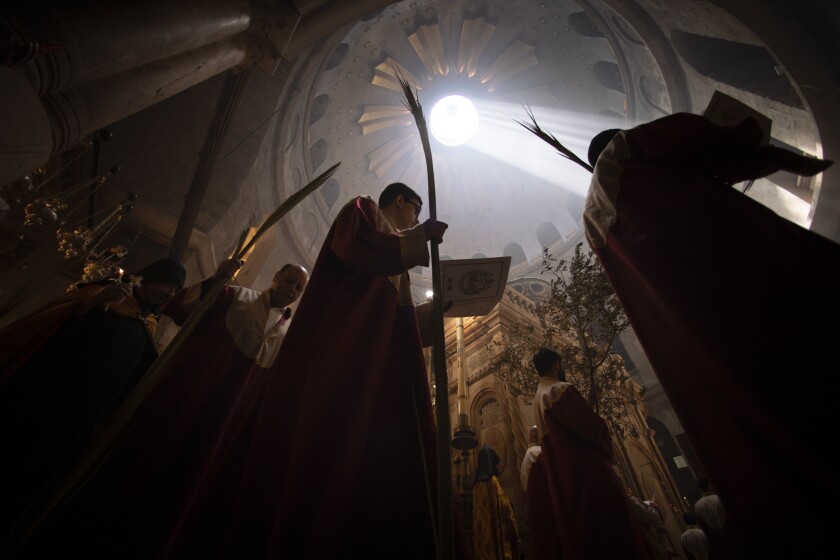 Priests hold palm fronds during the Palm Sunday procession at the Church of the Holy Sepulchre, where many Christians believe Jesus was crucified, buried and rose from the dead, in the Old City of Jerusalem, Sunday, April. 25, 2021. Followers of the Orthodox and Eastern Churches began marking Holy Week Sunday. (AP Photo/Oded Balilty)