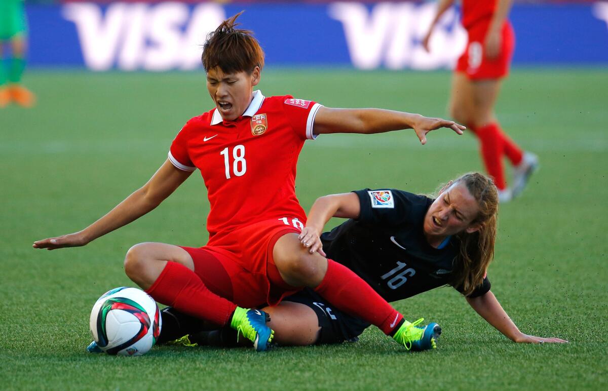 China forward Han Peng and New Zealand midfielder Annalie Longo get tangled as they battle for possession of the ball during their group game at the Women's World Cup on Monday.