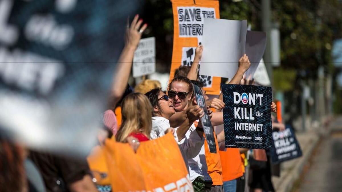 Protesters in Los Angeles in 2014 hold signs urging President Obama to save net neutrality.