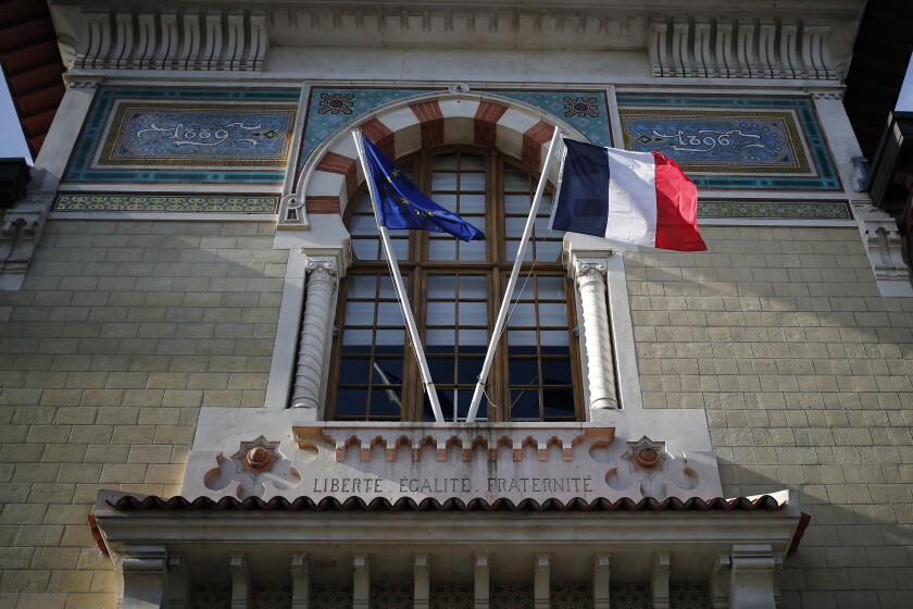 FILE - In this Thursday, Feb. 11, 2021 file photo, European and French flags fly at the entrance of the French National School of Administration, (ENA), in Paris. French President Emmanuel Macron on Thursday, April 8, 2021 detailed plans to do away with an elite academic institution that's a key symbol of the country's power establishment, replacing it with a more egalitarian version. Macron was addressing hundreds of civil servants by video conference about planned reforms in the top ranks of the civil service, including putting an end to the Ecole Nationale d’Administration, widely known as ENA. (AP Photo/Francois Mori, File)
