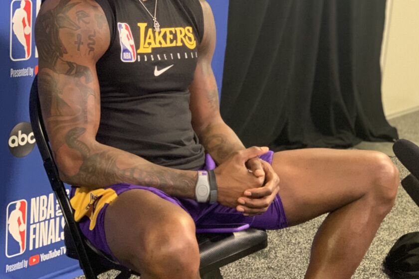 Lakers center Dwight Howard, in some purple-and-gold Kobe shoes by Nike, takes a break.