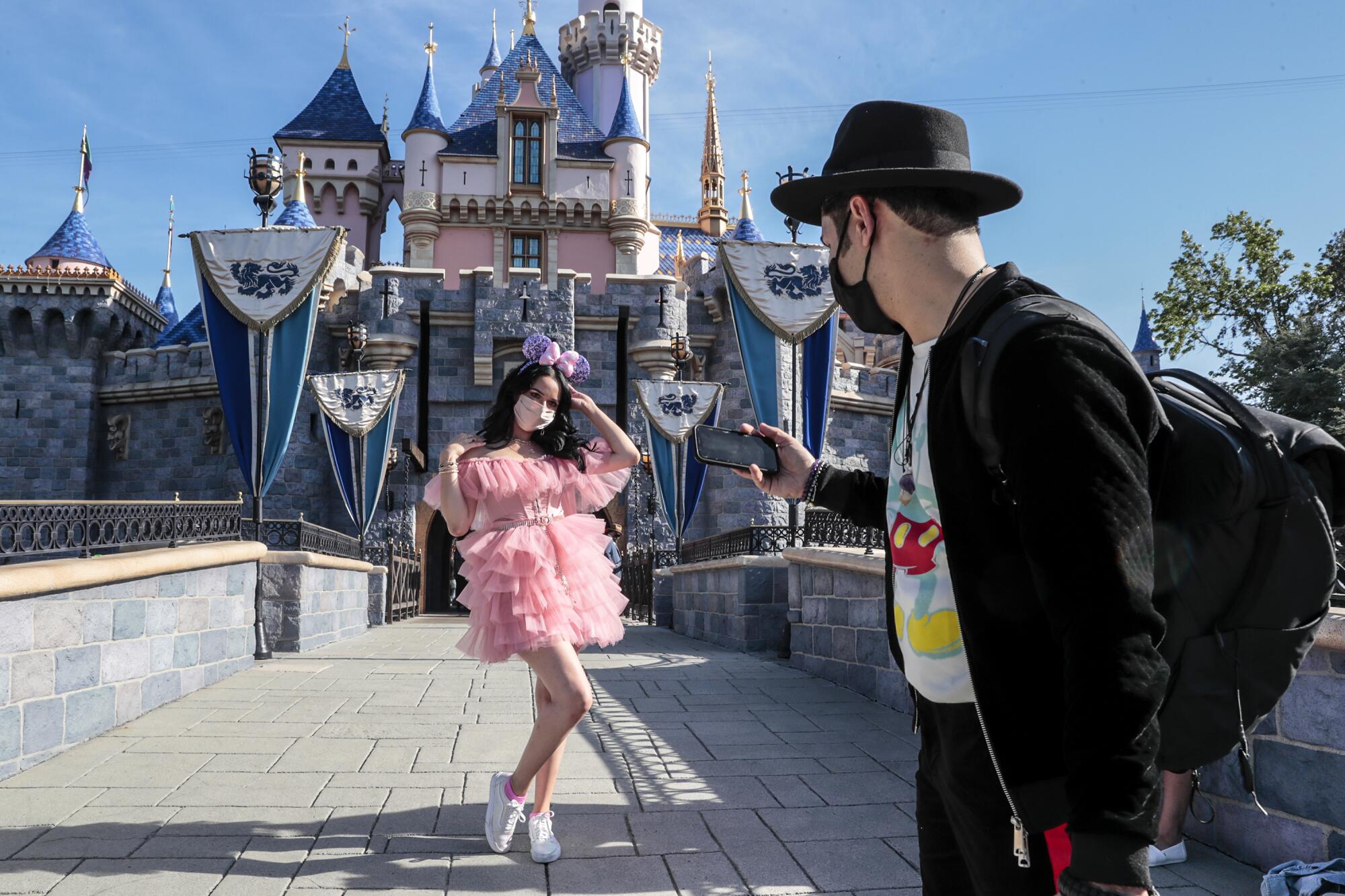 Minerva Mendez and Ahmed El take photos in front of Sleeping Beauty's Castle inside Disneyland.