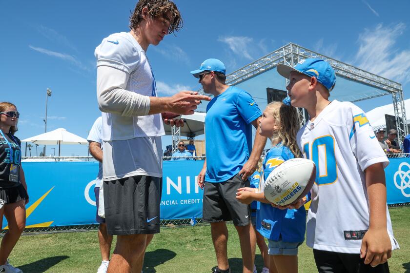 Chargers quarterback signs autographs for fans.