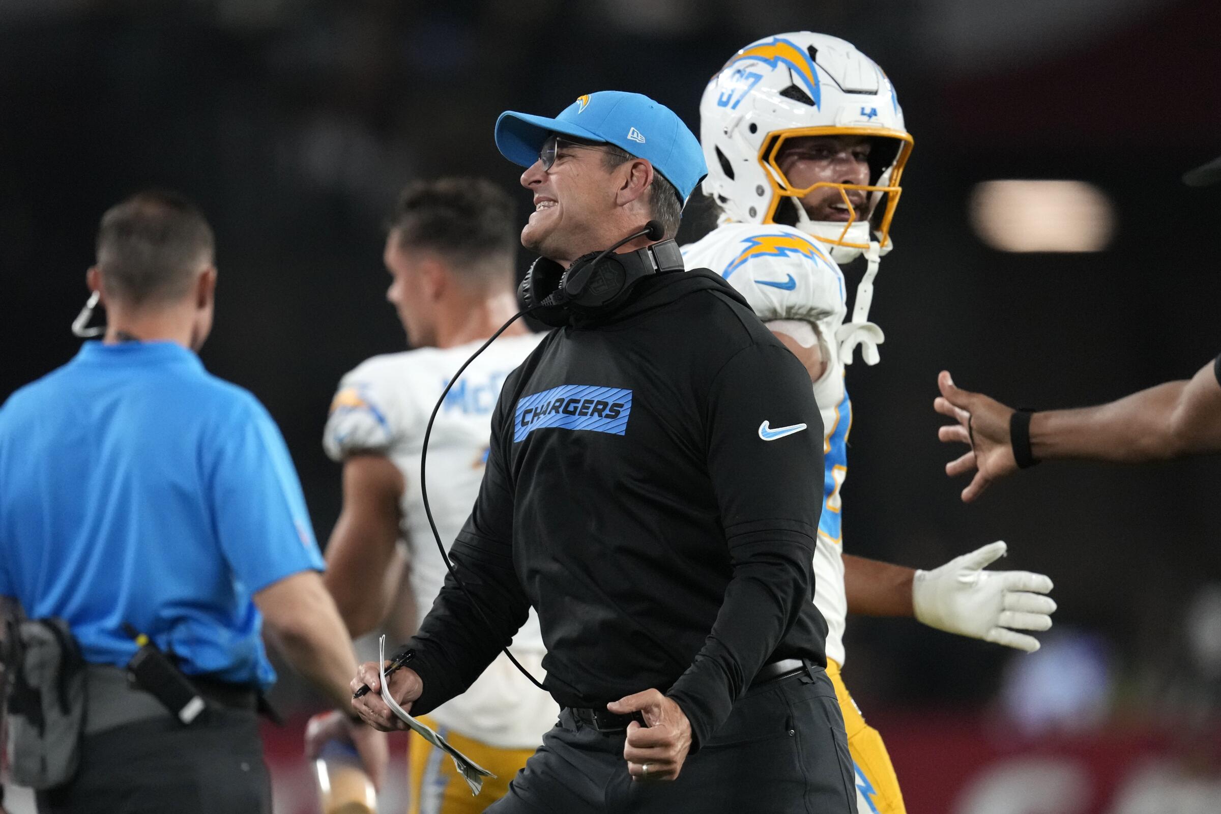 Chargers coach Jim Harbaugh grimaces and clenches a fist.