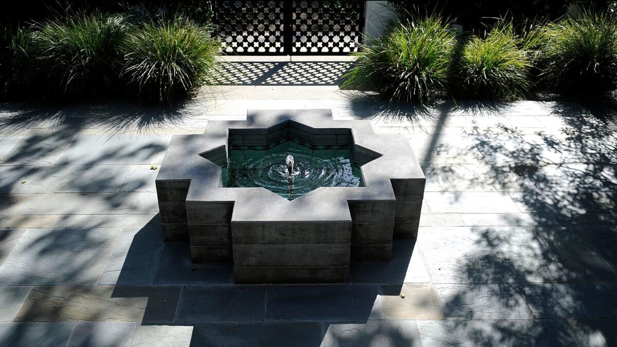 A Moroccan-inspired water fountain adds character to the small courtyard in front.