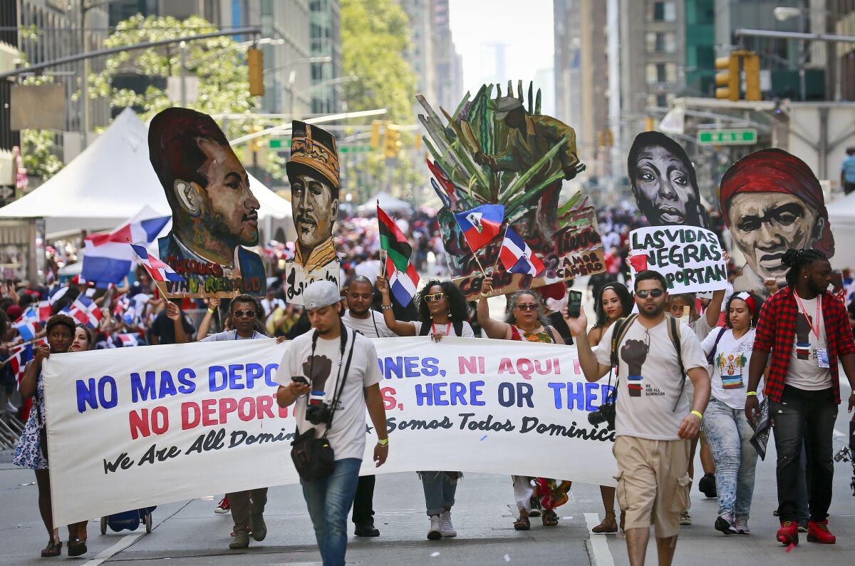 FILE - A group calling for the end of deportations marches in the Dominican Day Parade, Sunday, Aug. 13, 2017, in New York. A new report released Monday, May 2, 2022 by Pew Research Center says about 6 million adults in the United States identify as Afro Latino, a distinction with deep roots in colonial Latin America. That’s about 2% of the adult U.S. population and 12% of the adult Latino population in the U.S. Many Hispanic people identify themselves based on their ancestral countries of origin, their Indigenous roots or racial background. (AP Photo/Bebeto Matthews, File)