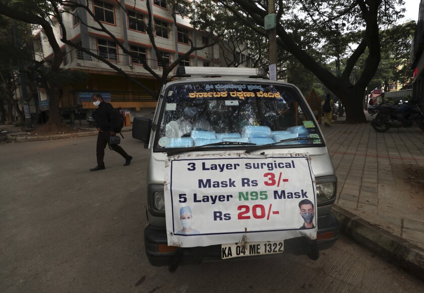 A vendor sells face masks to be used as a precaution against COVID-19 in Bengaluru, capital of the southern Indian state of Karnataka, Thursday, Dec. 2, 2021. India on Thursday confirmed its first cases of the omicron coronavirus variant in two men in Karnataka who came from abroad. (AP Photo/Aijaz Rahi)