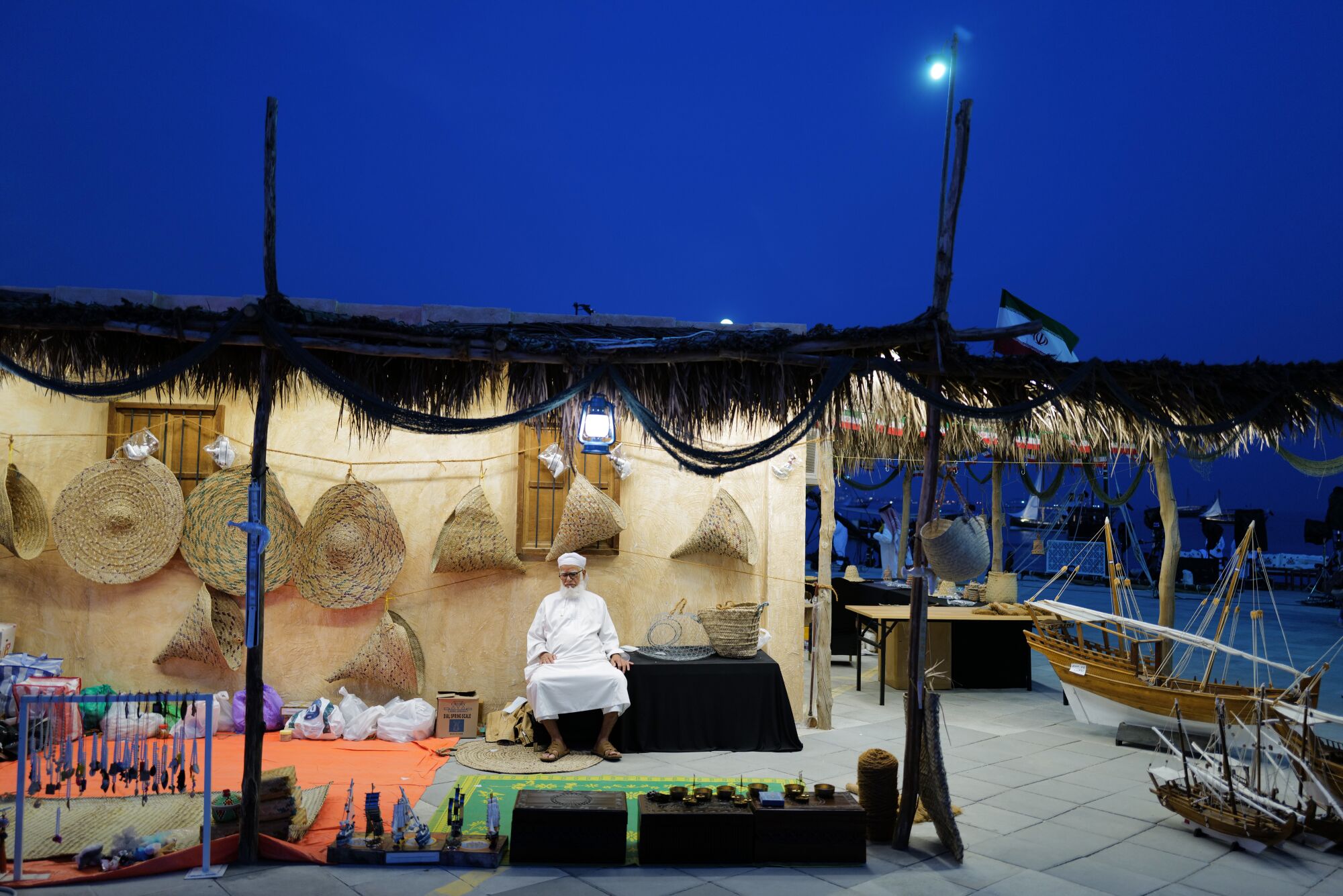 A local sits on his stall at the Katara Traditional Dhow Festival in Katara Cultural Village in Doha, Qatar.
