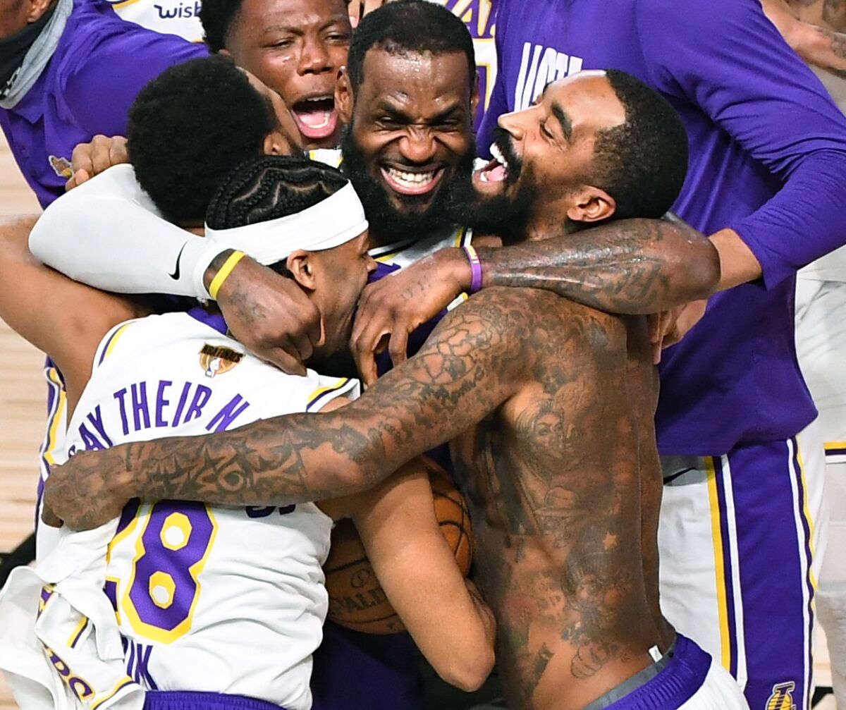 LeBron James, center, gives a group hug to several Lakers teammates, including a shirtless J.R. Smith