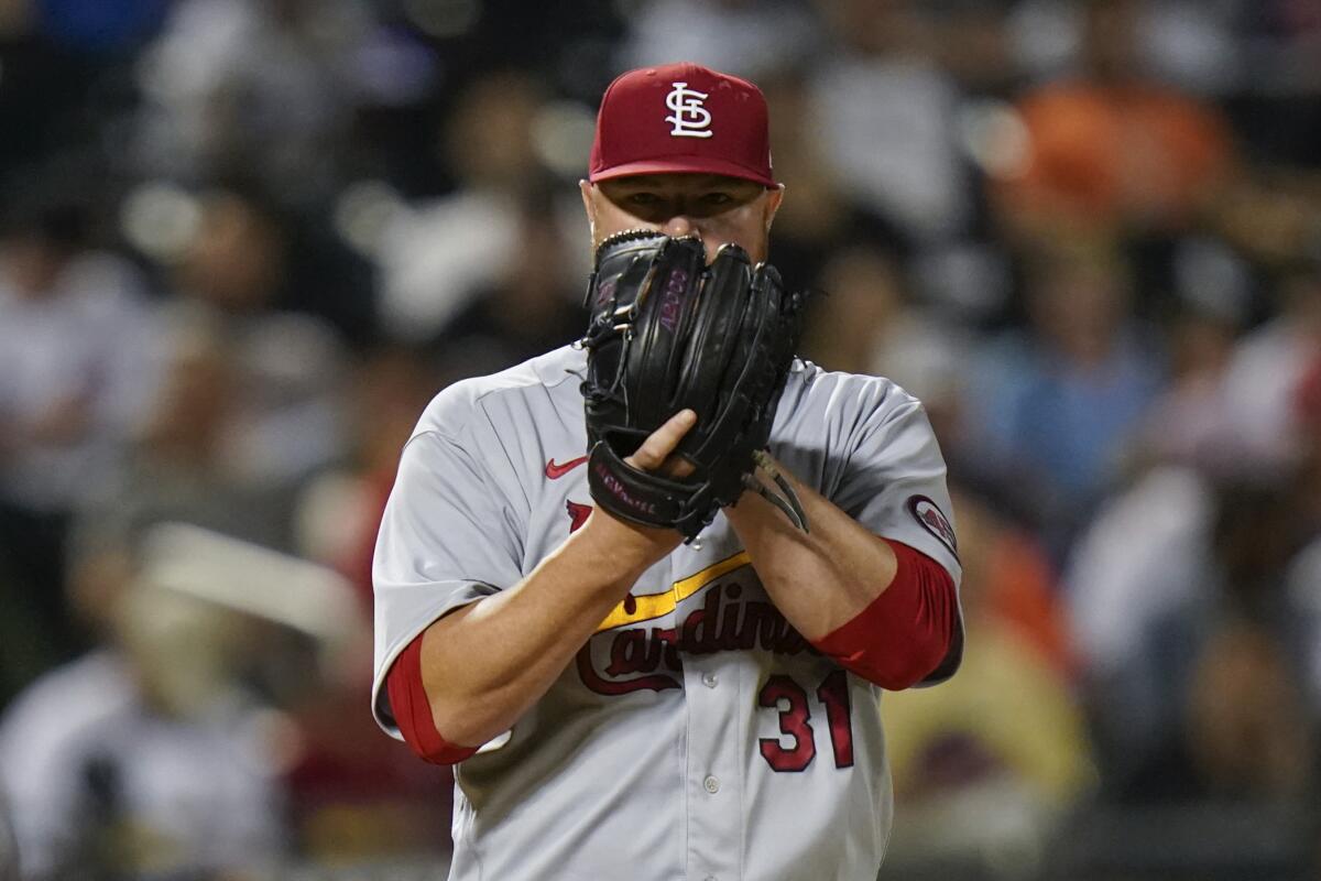 St. Louis Cardinals starting pitcher Jon Lester peers from behind his glove.