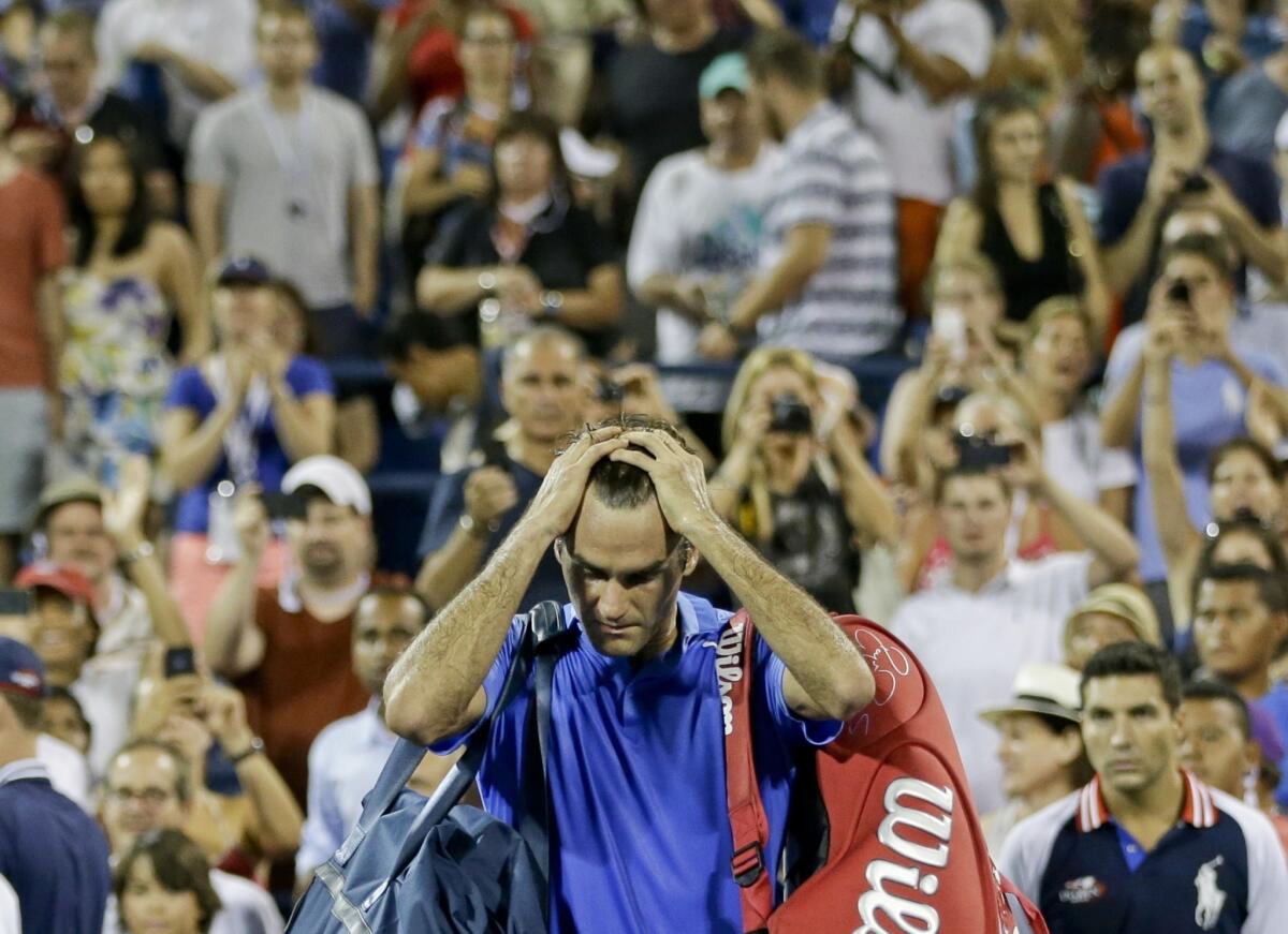 Roger Federer walks off the court after losing to Tommy Robredo in a fourth-round upset at the U.S. Open on Monday.