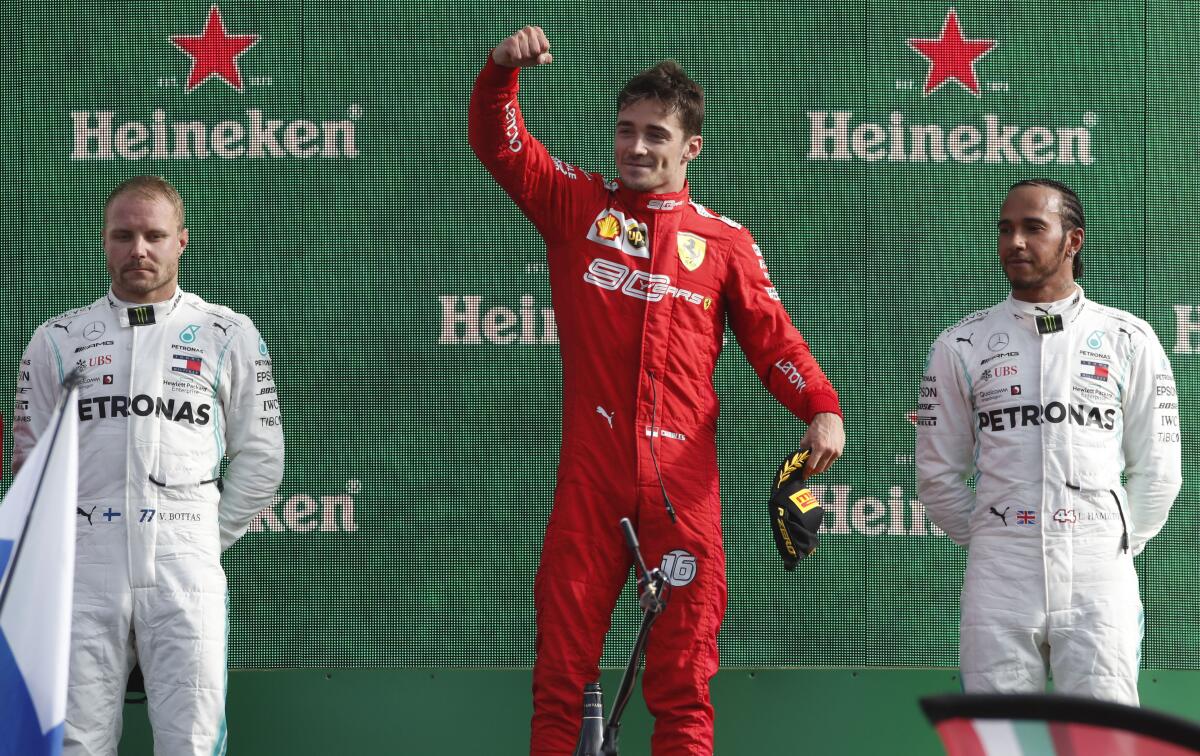 Ferrari driver Charles Leclerc, flanked by Mercedes drivers Valtteri Bottas, left, and Lewis Hamilton, right, celebrates on the podium after winning the Italian Grand Prix on Sunday.