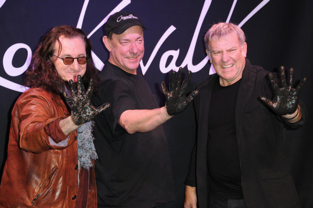 Canadian progressive-rock band Rush, here getting their handprints set in concrete at Guitar Center in Hollywood, lead fan voting for Rock and Roll Hall of Fame induction