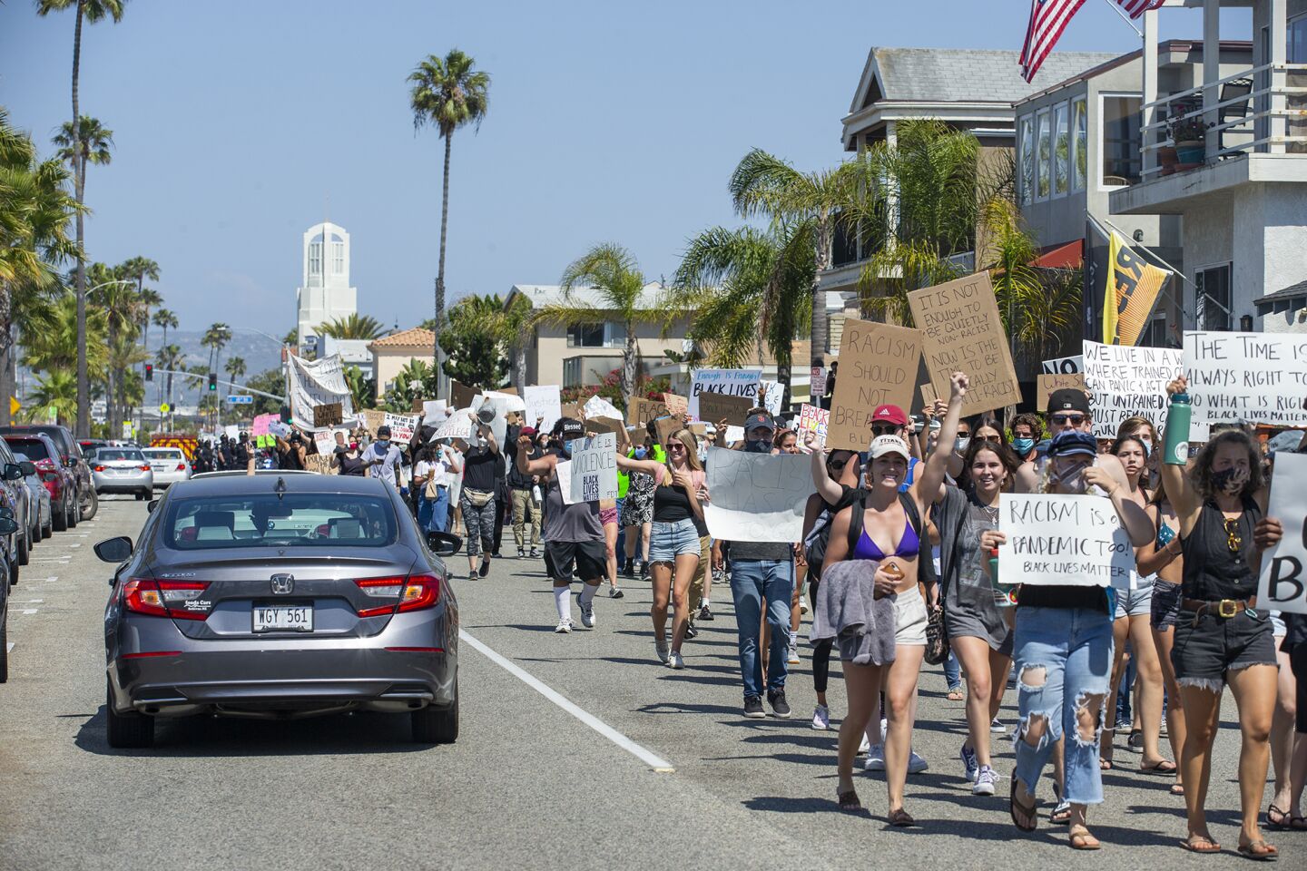 Demonstrators walk down Balboa Boulevard on Wednesday.