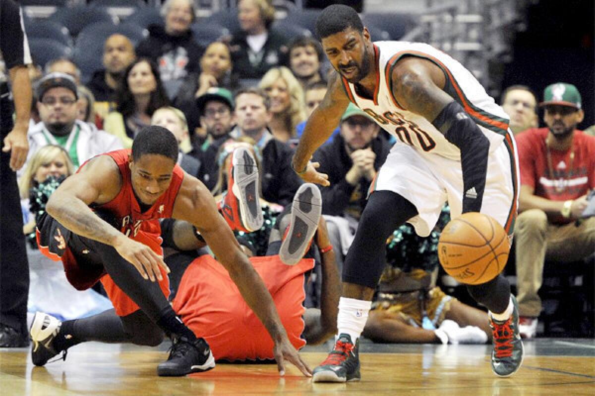 Toronto's DeMar DeRozan, left, slips as he and Milwaukee's O.J. Mayo, right, chase a loose ball during a preseason game at BMO Harris Bradley Center. The game was canceled because of safety concerns about the court in the first quarter.