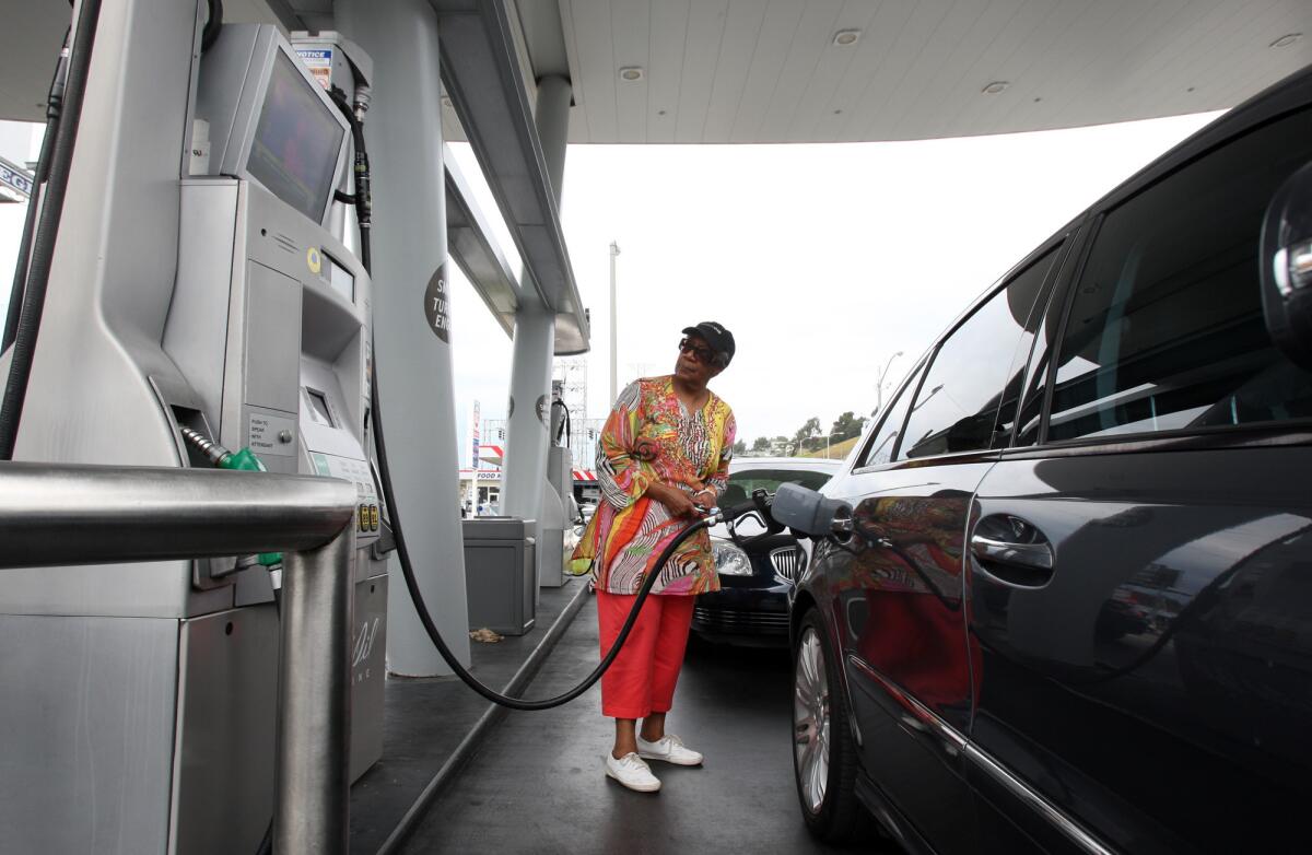 Eloise Ferguson of Ladera Heights pumps gas at a United Oil station at the intersection of Slauson and La Brea avenues in 2012.