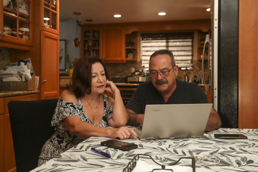 Walnut, CA - August 23: Susan Trigueros, 63, left, and her husband Mario Trigueros, 67, both retired go online to make travel plans at home on Tuesday, Aug. 23, 2022 in Walnut, CA. (Irfan Khan / Los Angeles Times)