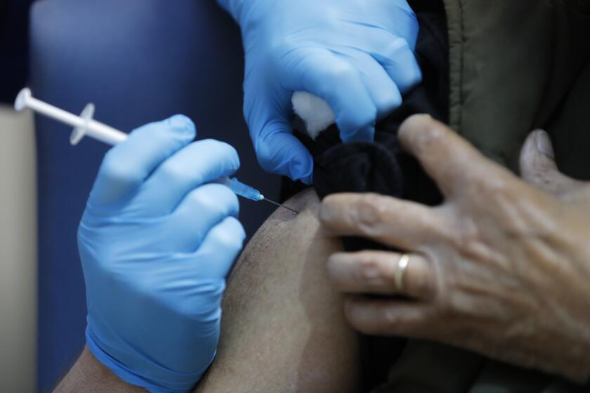 A nurse administers the Pfizer-BioNTech COVID-19 vaccine at Guy's Hospital in London, Tuesday, Dec. 8, 2020. U.K. health authorities rolled out the first doses of a widely tested and independently reviewed COVID-19 vaccine Tuesday, starting a global immunization program that is expected to gain momentum as more serums win approval. (AP Photo/Frank Augstein, Pool)