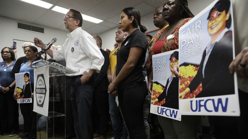 John Grant, president of the United Food and Commercial Workers Local 770, stands with members of UFCW and other unions as he argues for better pay for its members. The UFCW approved a strike motion Monday afternoon.