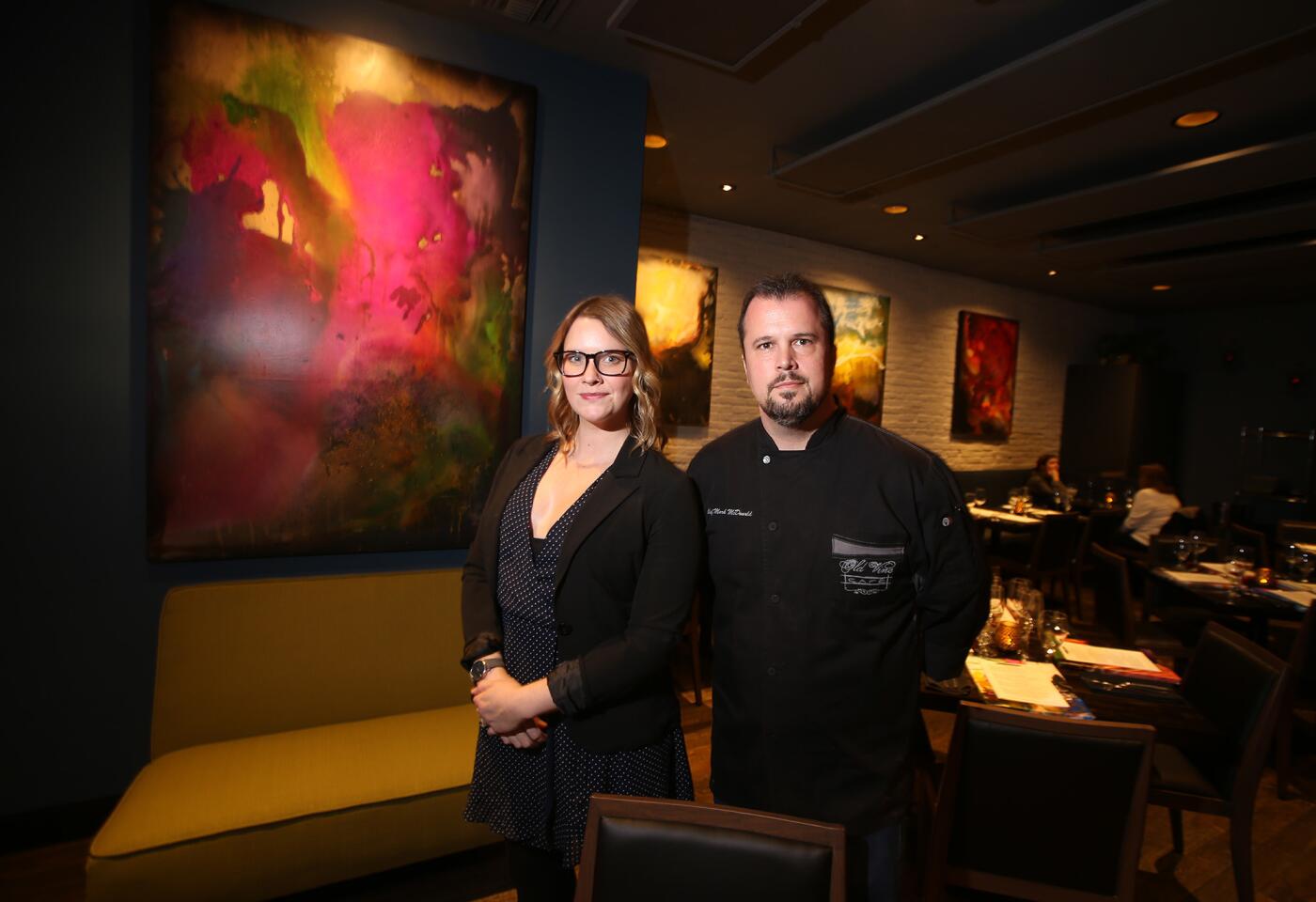 Co-owners Kate Perry and chef Mark McDonald stand in the dining room of Old Vine Kitchen + Bar in Costa Mesa. Paul Kole's artwork adorns the walls.