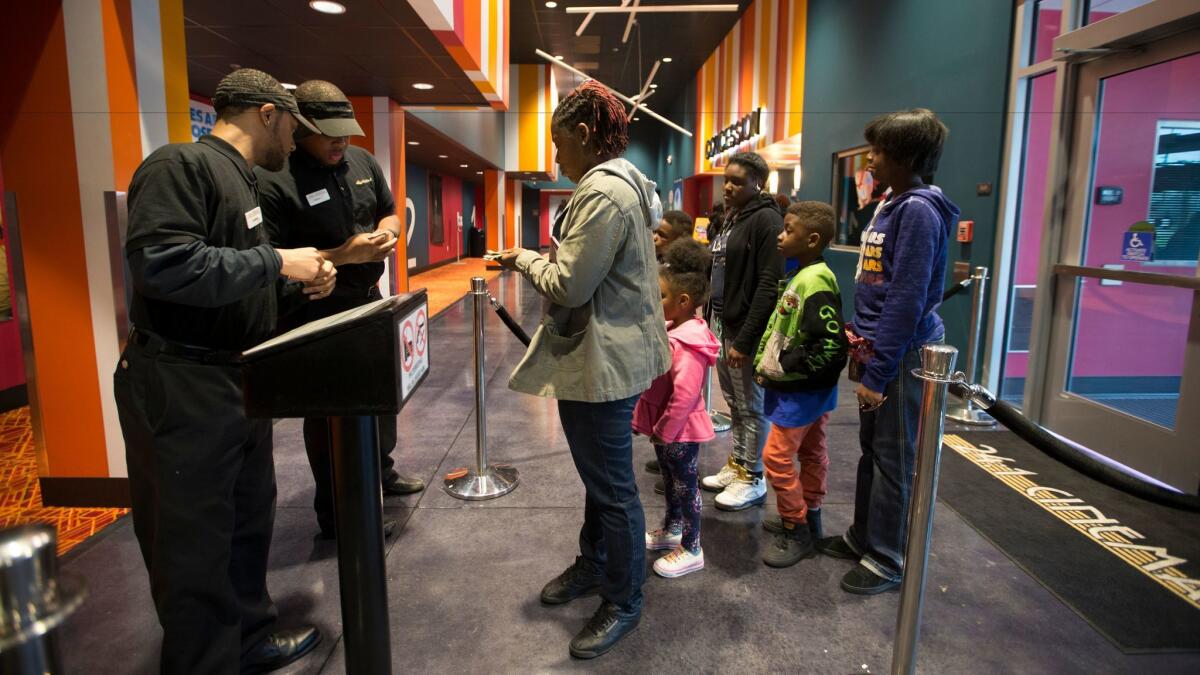 Ushers check tickets at 24:1 Cinema.