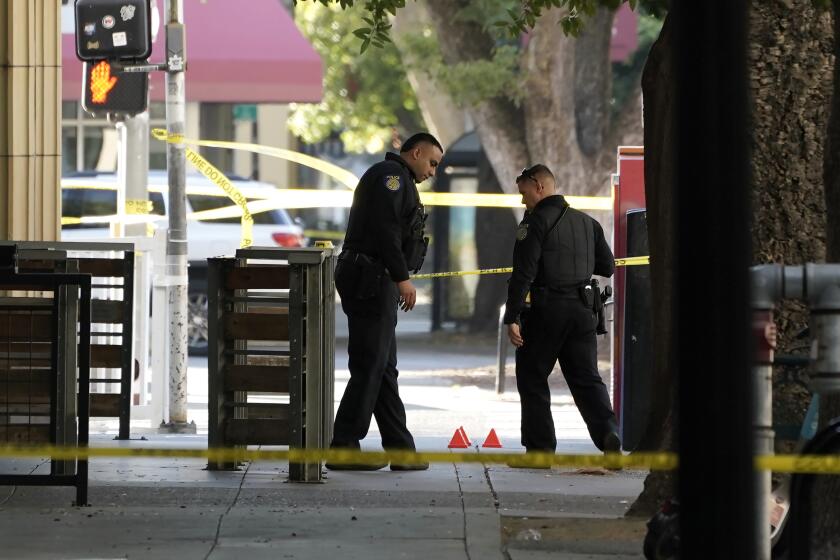 Sacramento Police officers look over evidence markers near the scene of a fatal shooting outside of a downtown Sacramento, Calif., night club in the early morning hours on Monday, July 4, 2022. (AP Photo/Rich Pedroncelli)