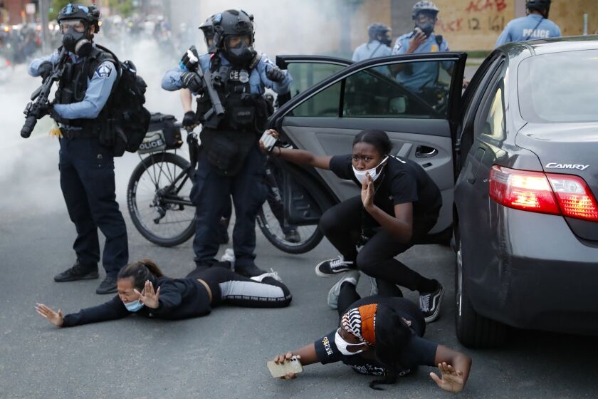 Motorists are ordered to the ground from their vehicle by police on May 31, 2020, during a protest in Minneapolis over the death of George Floyd, a Black man who died after a white Minneapolis police officer pressed a knee into his neck for several minutes. (AP Photo/John Minchillo)