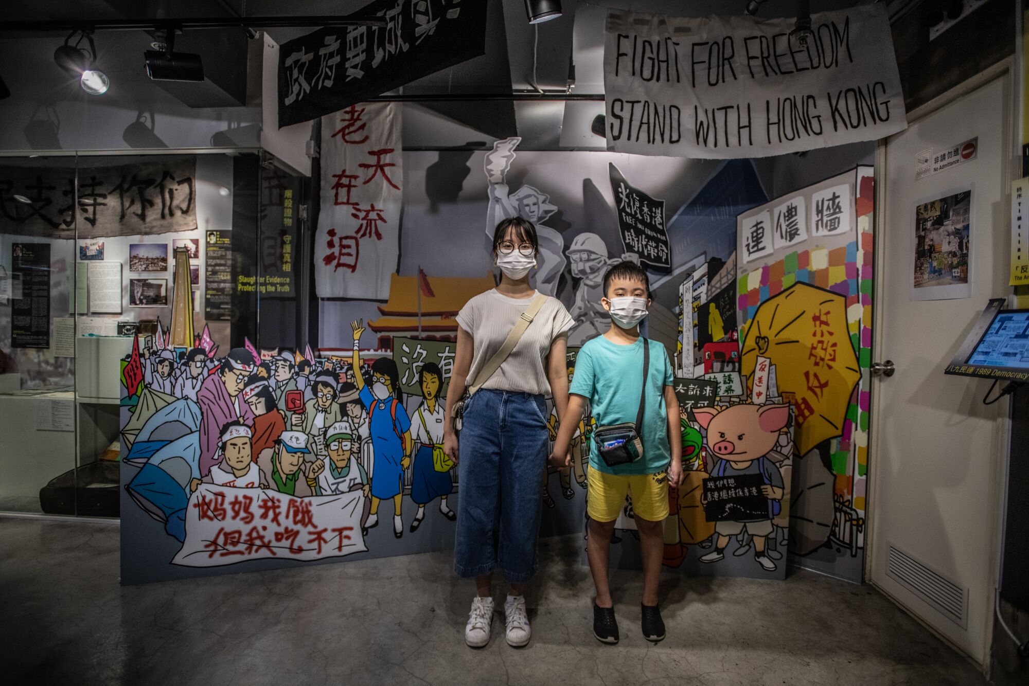 Amy Chan and brother Aaron pose in front of a display at the June 4 museum in Hong Kong.
