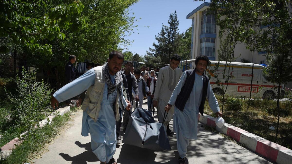 Afghan volunteers on May 31, 2017, carry the body of a resident killed in a car bomb attack to the Wazir Akbar Khan hospital in Kabul.
