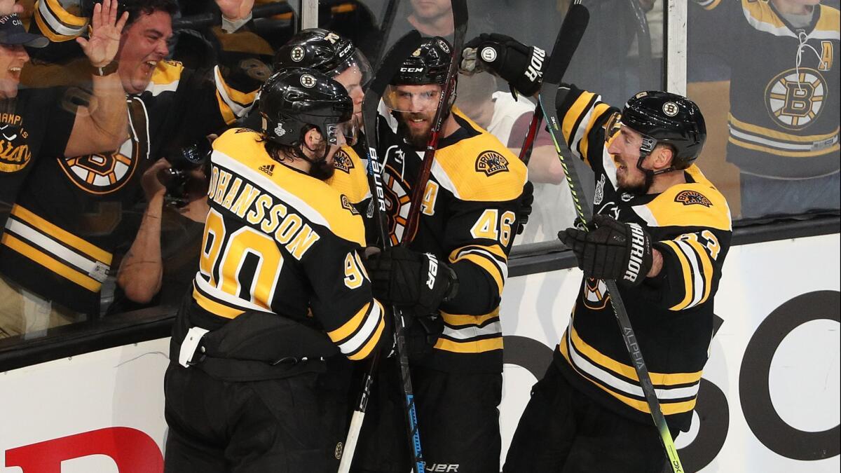 Boston Bruins forward Charlie McAvoy, second left, celebrates with teammates after scoring against the St. Louis Blues in Game 1 of the Stanley Cup Final on May 27.