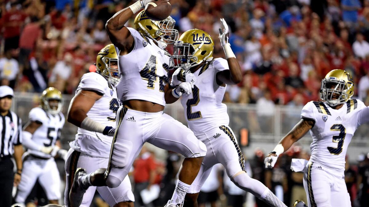 UCLA linebacker Kenny Young (42) celebrates after returning an interception for a touchdown against UNLV on Saturday night.